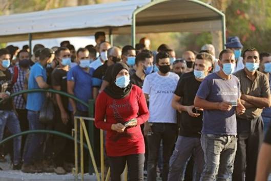 Travailleurs palestiniens à un poste de contrôle pour entrer à Jérusalem. © MENAHEM KAHANA / AFP